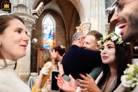 At Eglise de Gouvieux, the bride and groom are warmly embraced by family and guests at the end of the ceremony, capturing genuine affection and support as the newlyweds are welcomed into joyous celebration.